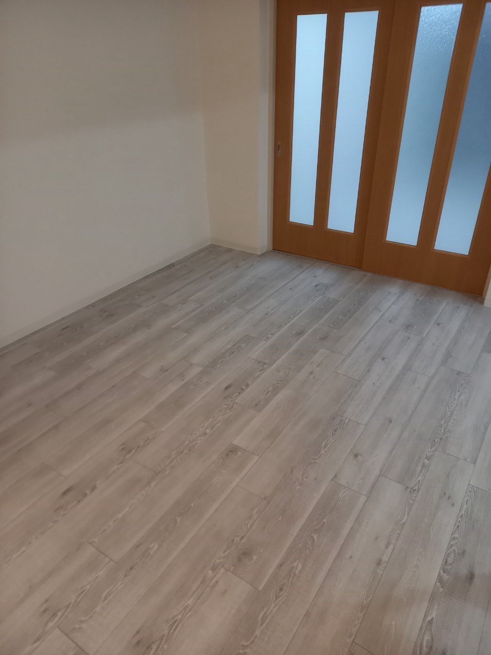 明るい床と壁に、木目のガラス入り建具を合わせました。
