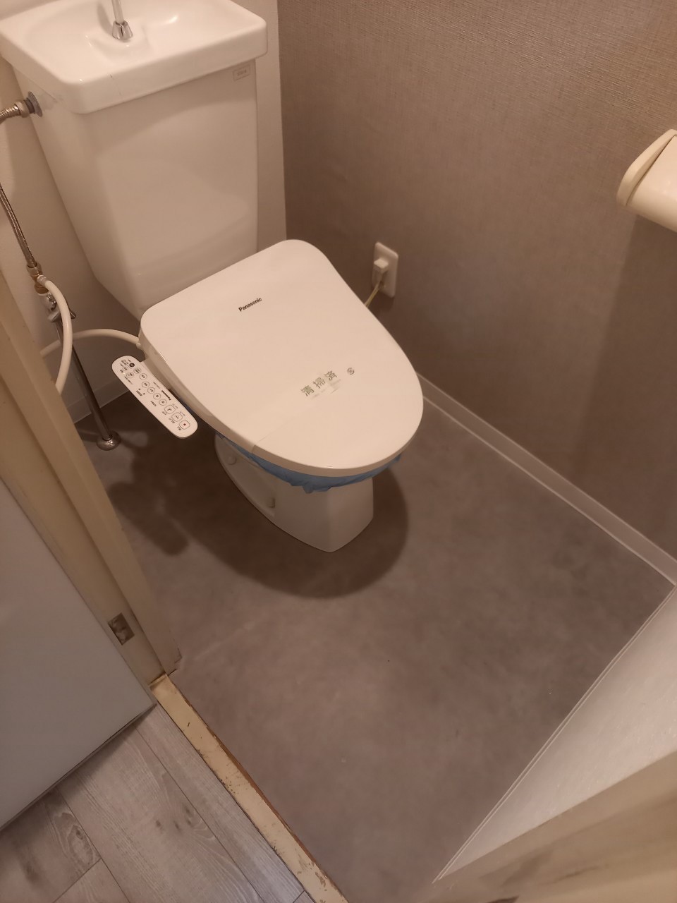 入口から便器まわりまで床を整え、壁面と合わせて統一感のある仕上がりに。